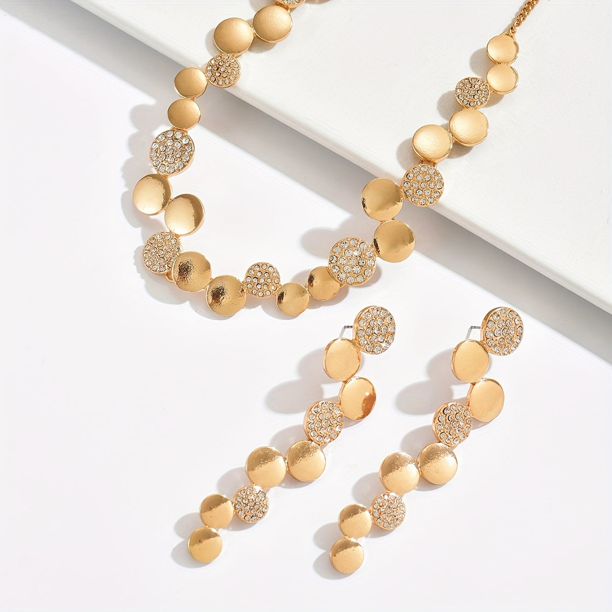 Um conjunto de joalharia de metal de duas peças, elegante e minimalista, com formas geométricas brilhantes redondas, brincos e colar criativos abstratos combinados irregularmente, perfeito para festas e eventos do dia a dia.