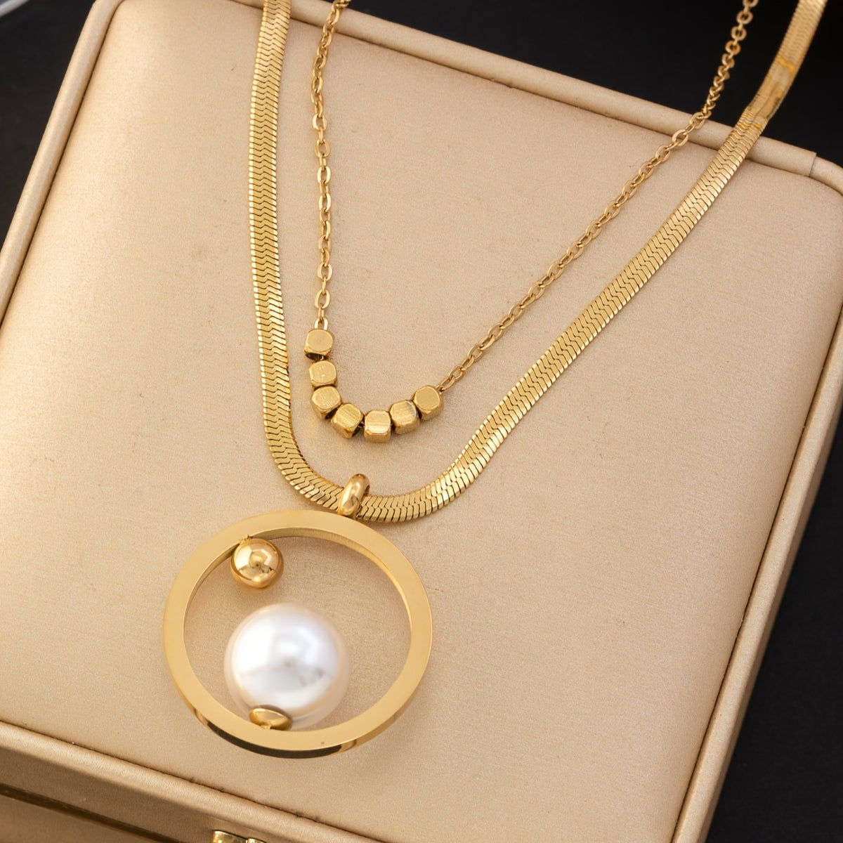 Um conjunto elegante de quatro peças com um colar, brincos e anel em aço inoxidável dourado, perfeito para mulheres usarem diariamente, em encontros ou como presente.